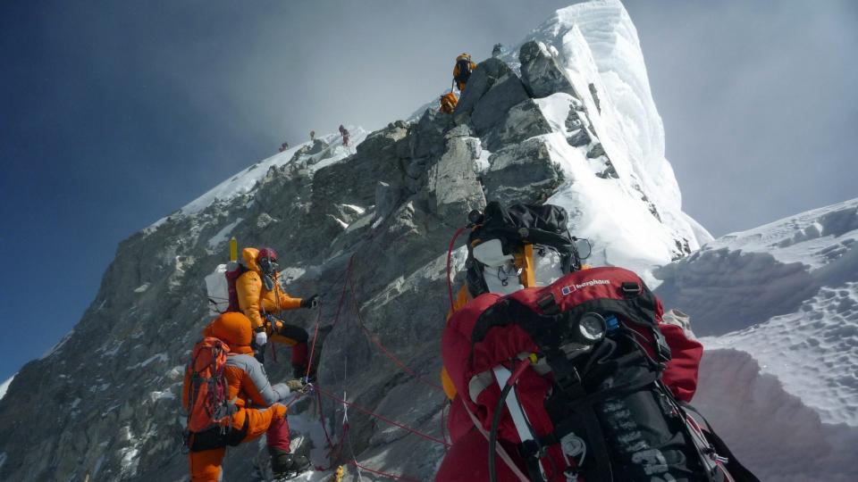 n this May 19, 2009 file photograph, unidentified mountaineers walk past the Hillary Step while pushing for the summit of Mount Everest as they climb the south face from Nepal.