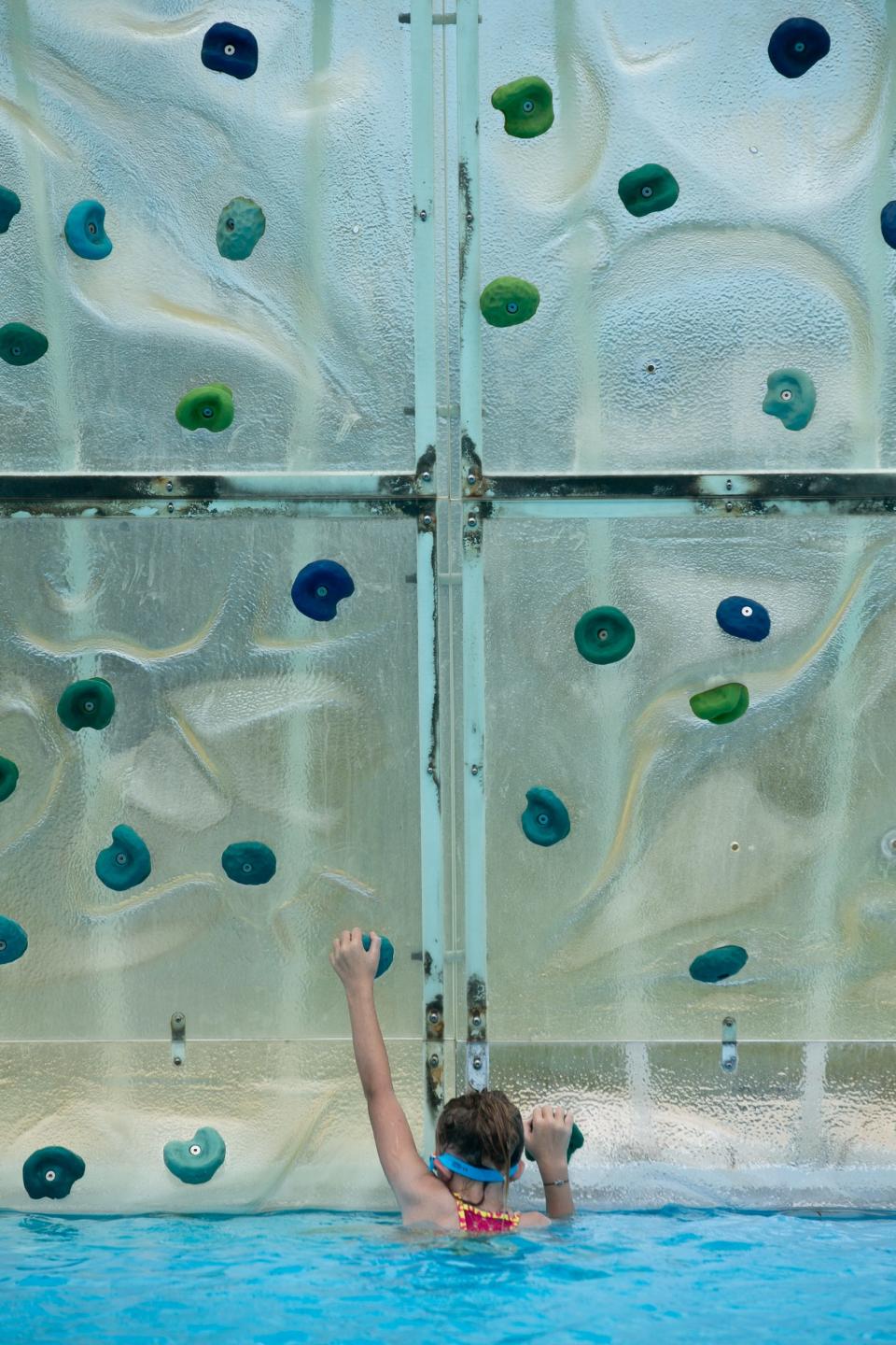 Chrysta Sigler, 9, attempts a go at a rock climb at West Guth Pool Thursday, July 6, 2023.