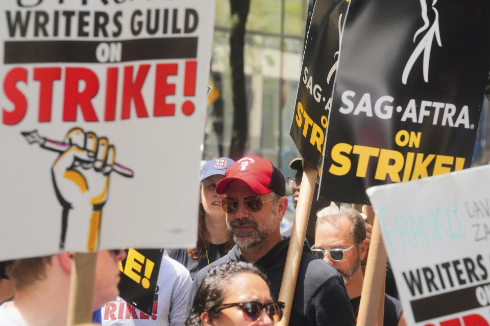 Actor Jason Sudeikis, center, walks a picket line with striking writers and actors, Friday, July 14, 2023, at NBC Universal Studios in New York. The picketing comes a day after the main actors’ union voted to join screenwriters in a double-barreled strike for the first time in more than six decades. The dispute immediately shut down production across the entertainment industry after talks for a new contract with studios and streaming services broke down. (AP Photo/Bebeto Matthews)