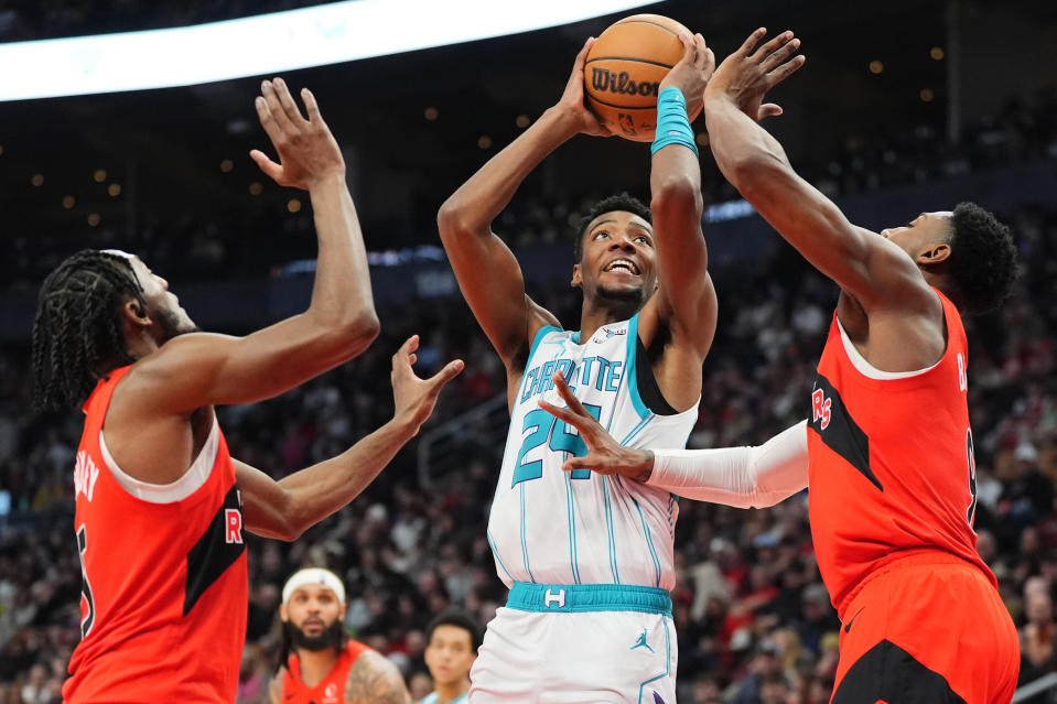 Charlotte Hornets forward Brandon Miller, center, looks toward the basket as Toronto Raptors guards Immanuel Quickley, right, and RJ Barrett defend during first-half NBA basketball game action in Toronto, Sunday, March 3, 2024. (Frank Gunn/The Canadian Press via AP)