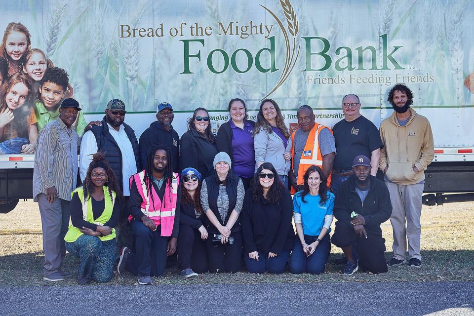 Staff of the Bread of the Mighty food bank in Gainesville pose for a joint photo at a food distribution event. The food bank recently merged with Jacksonville-based Feeding Northeast Florida.