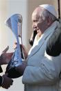 Pope Francis is presented with the replica of the trophy that Argentinian soccer team San Lorenzo won in the Argentinian soccer championship, during the Wednesday general audience in Saint Peter's square at the Vatican December 18, 2013. REUTERS/Tony Gentile