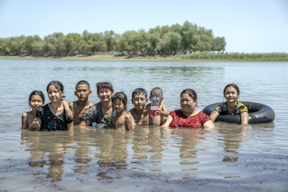 People swim in the Amu Darya River, near Muynak, Uzbekistan, Wednesday, July 12, 2023. (AP Photo/Ebrahim Noroozi)