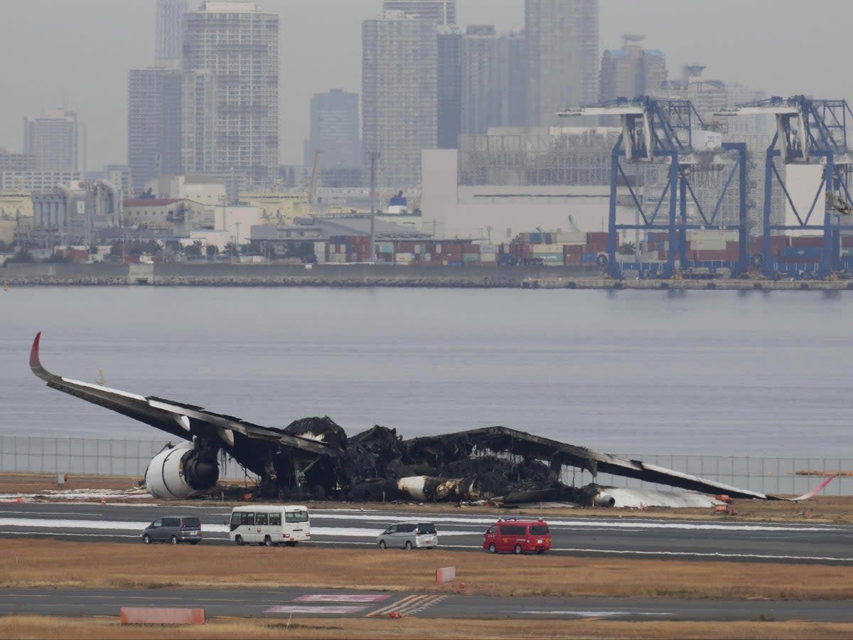 The burn-out wreckage of Japan Airlines plane is seen at Haneda airport (AP)