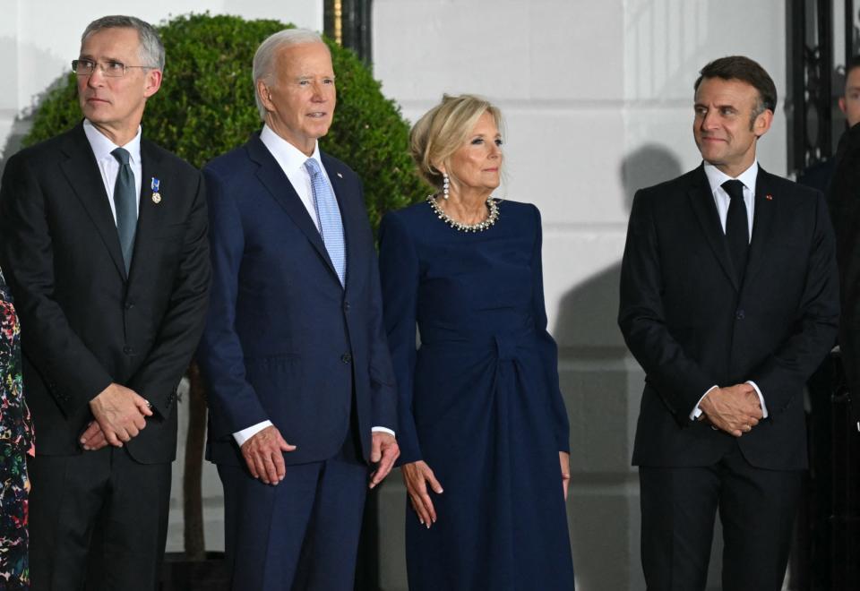 French President Emmanuel Macron (R) looks at US President Joe Biden (2nd L), First Lady Jill Biden (2nd R) and NATO Secretary General Jens Stoltenberg (L) as the Bidens welcome guests for a dinner with NATO Allies and partners at the White House in Washington, DC, on July 10, 2024 on the sidelines of the NATO 75th anniversary summit. (Photo by SAUL LOEB / AFP) (Photo by SAUL LOEB/AFP via Getty Images)