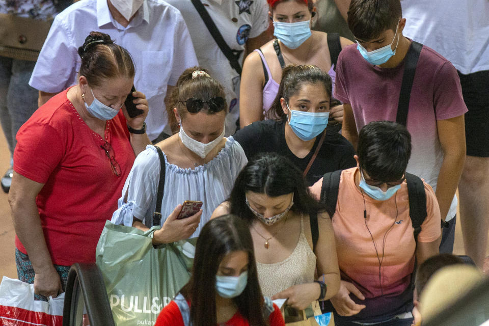 Numerosas personas con mascarillas para protegerse del coronavirus aguardan el tren el jueves 27 de agosto de 2020 en un andén en la estación de Atocha, en Madrid, España.