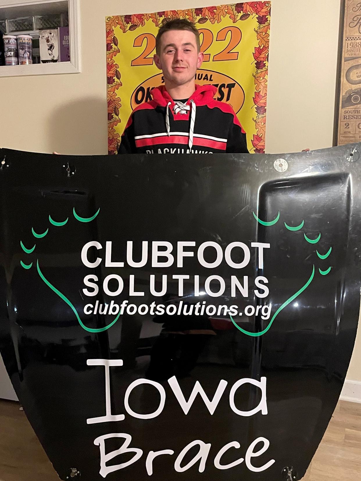 Clay Curts, treated for clubfoot as a baby, shows off the new hood paint scheme for the car he planned to race at Hawkeye Downs on Friday of this week to promote Clubfoot Solutions.