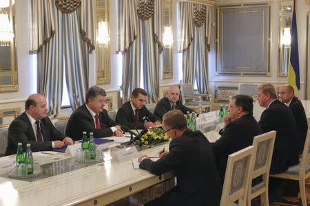 Ukrainian President Petro Poroshenko (2nd L) addresses outgoing European Commission President Jose Manuel Barroso (3rd R) during their meeting in Kiev, September 12, 2014. REUTERS/Valentyn Ogirenko