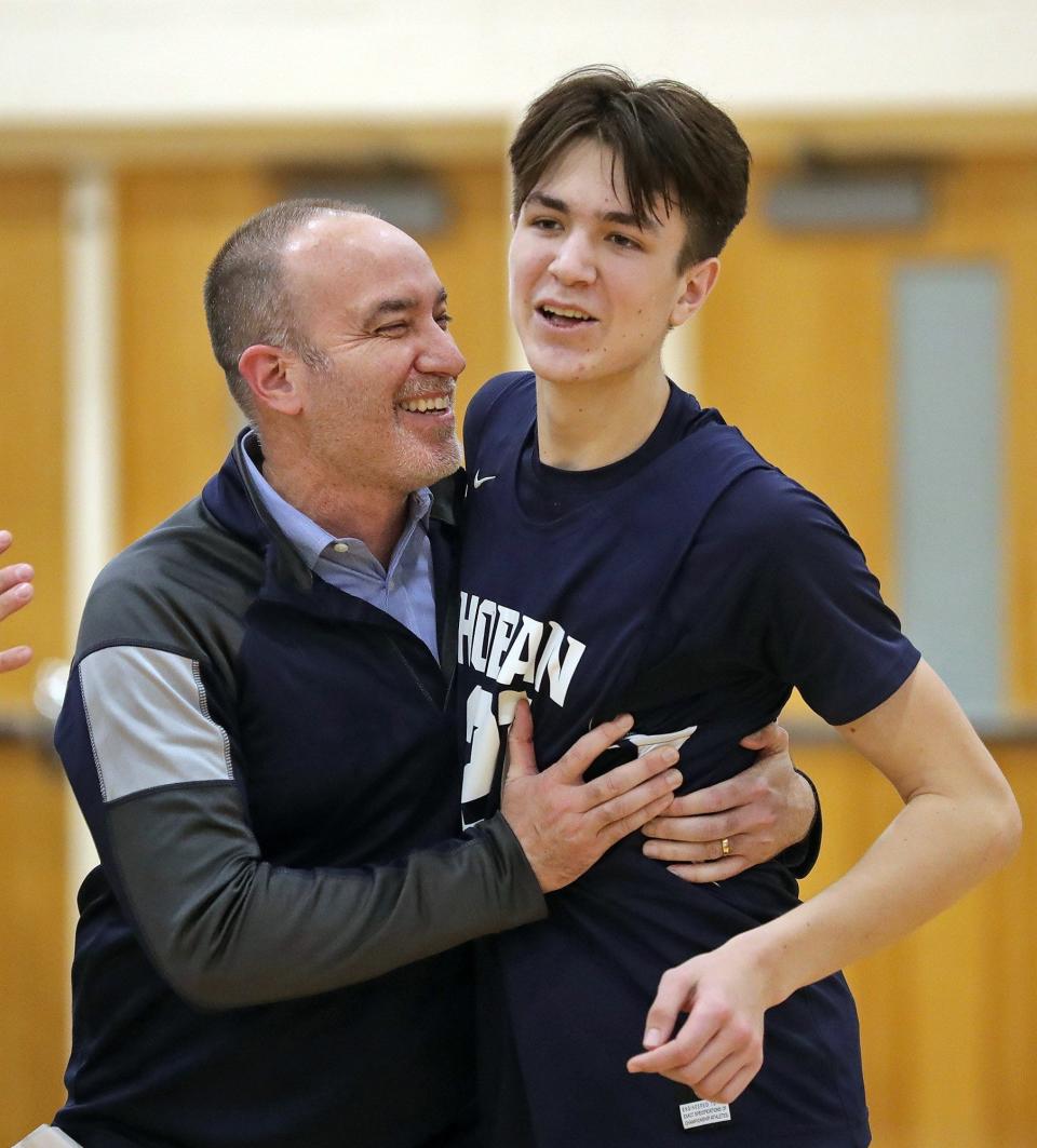 Hoban basketball coach TK Griffith celebrates with his son Andrew after beating Jackson in a Division I district final, Saturday, March 5, 2022, in Twinsburg.