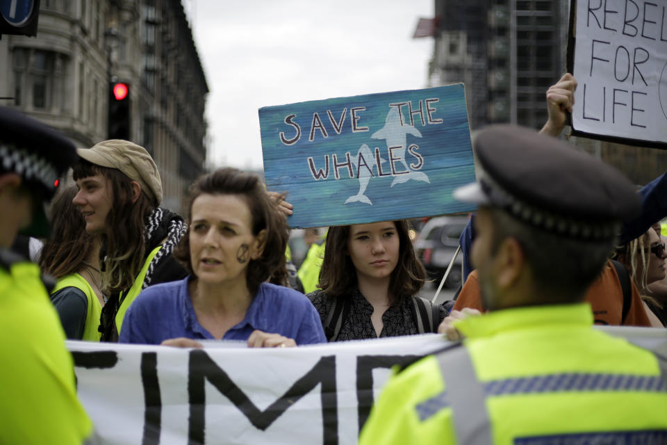 Extinction Rebellion climate change protesters hold banners as they briefly block traffic around Parliament Square in central London, Wednesday, April 24, 2019. The non-violent protest group, Extinction Rebellion, is seeking negotiations with the government on its demand to make slowing climate change a top priority. (AP Photo/Matt Dunham)