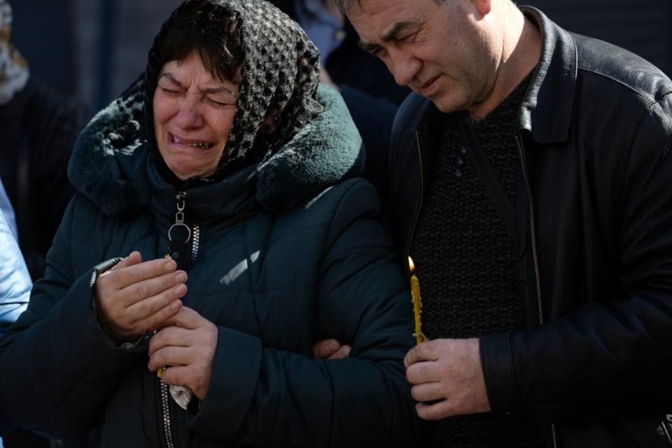 Relatives mourn fallen soldiers in Irpin, on the outskirts of Kyiv (AP)