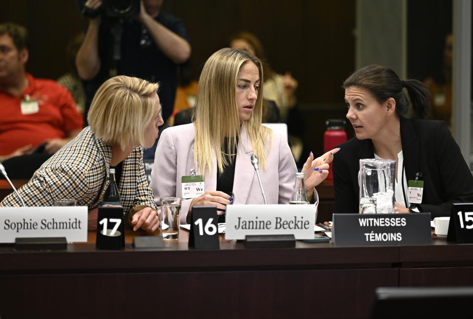 Canadian national soccer team players Sophie Schmidt, left, Janine Beckie and Christine Sinclair, right, prepare to appear before the Standing Committee on Canadian Heritage in Ottawa, studying safe sport in Canada, Thursday, March 9, 2023. (Justin Tang/The Canadian Press via AP)