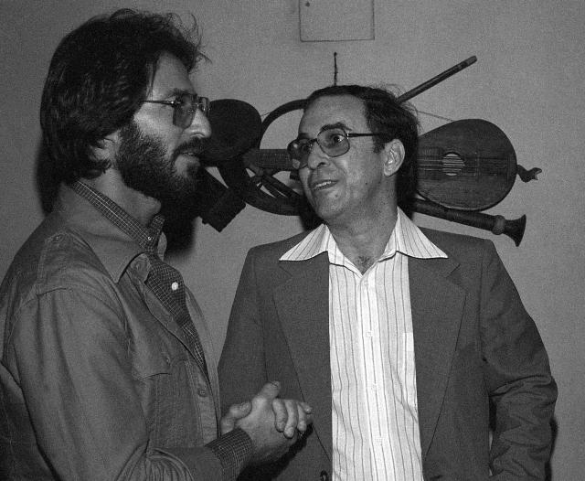 FILE - In this July 1978 file photo, Brazilian Joao Gilberto, right, chats backstage with a fan at the Newport Jazz Festival at Carnegie Hall in New York. The Brazilian singer and composer, who is considered one of the fathers of the Bossa Nova genre, has died. His death was confirmed by his children on Saturday, July 6, 2019. Gilberto was 88 years old. (AP Photo, File)