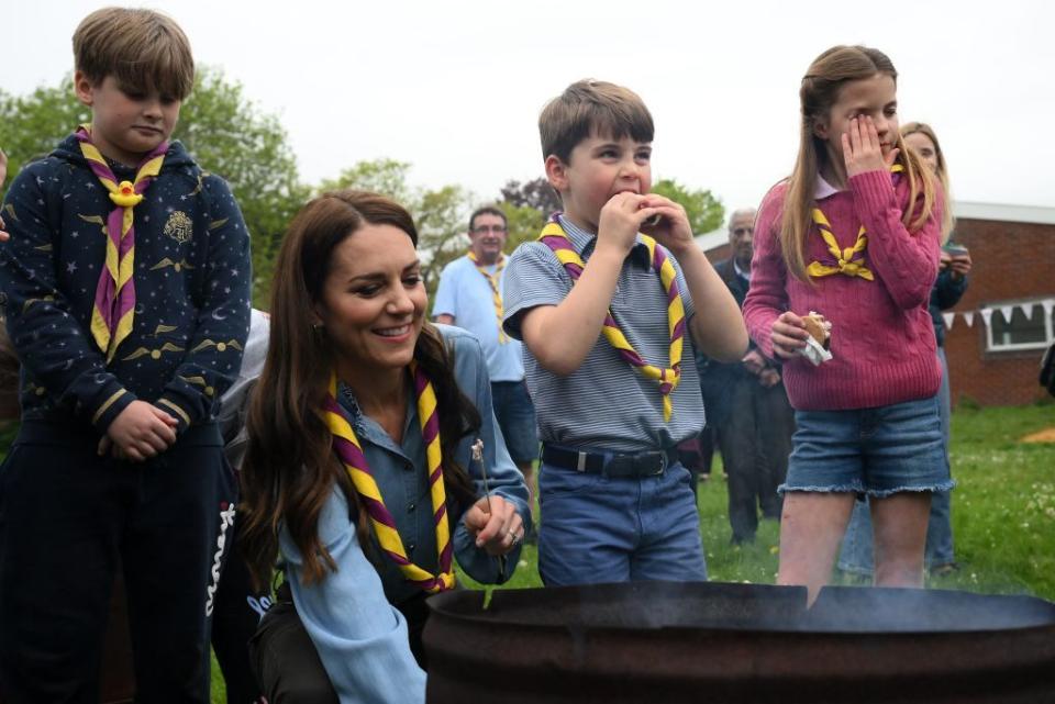 britains princess charlotte of wales r wipes her eyes as she and her brother britains prince louis of wales c eat marshmallow biscuits as they take part in the big help out, during a visit to the 3rd upton scouts hut in slough, west of london on may 8, 2023, where the family joined volunteers helping to renovate and improve the building people across britain were on monday asked to do their duty as the celebrations for king charles iiis coronation drew to a close with a massive volunteering drive photo by daniel leal pool afp photo by daniel lealpoolafp via getty images