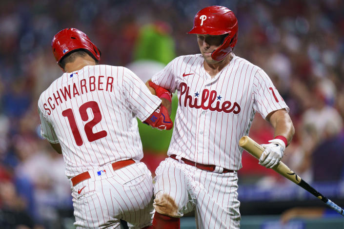 Philadelphia Phillies' Kyle Schwarber, left, celebrates his home run with Rhys Hoskins, right, during the seventh inning of a baseball game against the Washington Nationals, Friday, Aug. 5, 2022, in Philadelphia. (AP Photo/Chris Szagola)