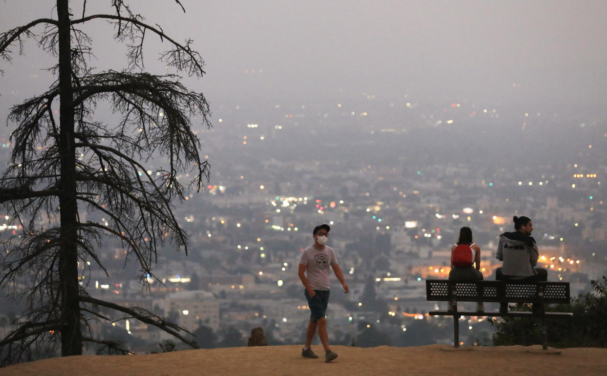People gather after sunset amid smoke from wildfires at Griffith Park 