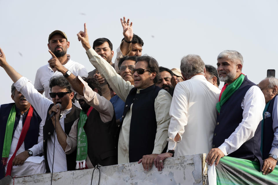 Pakistan's former Prime Minister Imran Khan, center, gestures to his supporters at a rally in Lahore, Pakistan, Saturday, Oct. 29 2022. Khan along with thousands of his supporters in a large convoy of buses and cars Friday began his much-awaited march on the capital Islamabad from the eastern city of Lahore to demand the holding of snap elections, a sign of deepening political turmoil. (AP Photo/K.M. Chaudary)