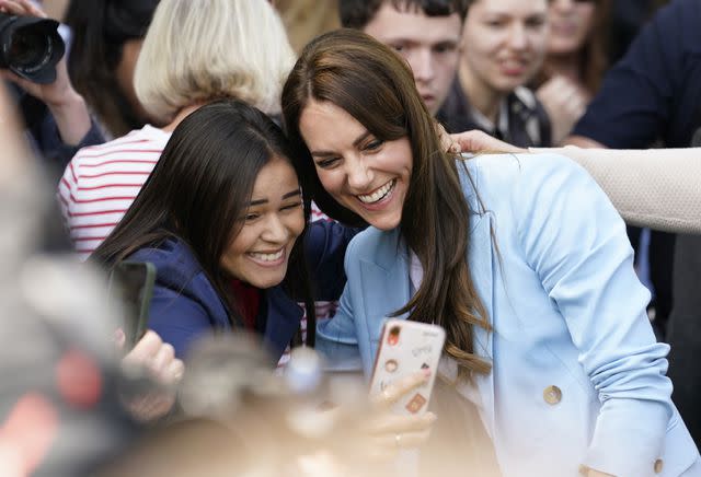 <p>Getty</p> Kate Middleton smiles for a selfie during a walkabout meeting members of the public on the Long Walk near Windsor Castle on May 7.