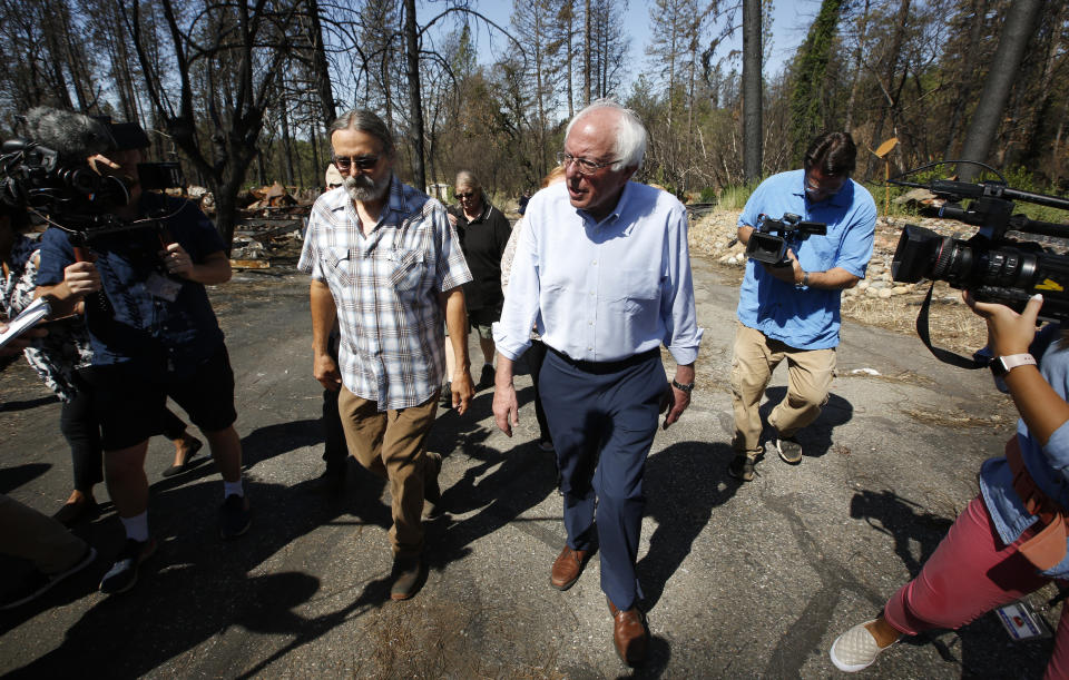 Democratic presidential candidate Sen. Bernie Sanders, I-Vermont,right, talks with area resident Michael Ranney as he tours a mobile home park that was destroyed by last year's wildfire in Paradise, Calif., Thursday, Aug. 22, 2019. Sanders released a $16.3 trillion climate plan Thursday that builds on the Green New Deal and calls for the United States to move to renewable energy across the economy by 2050 and declare climate change a national emergency. (AP Photo/Rich Pedroncelli)