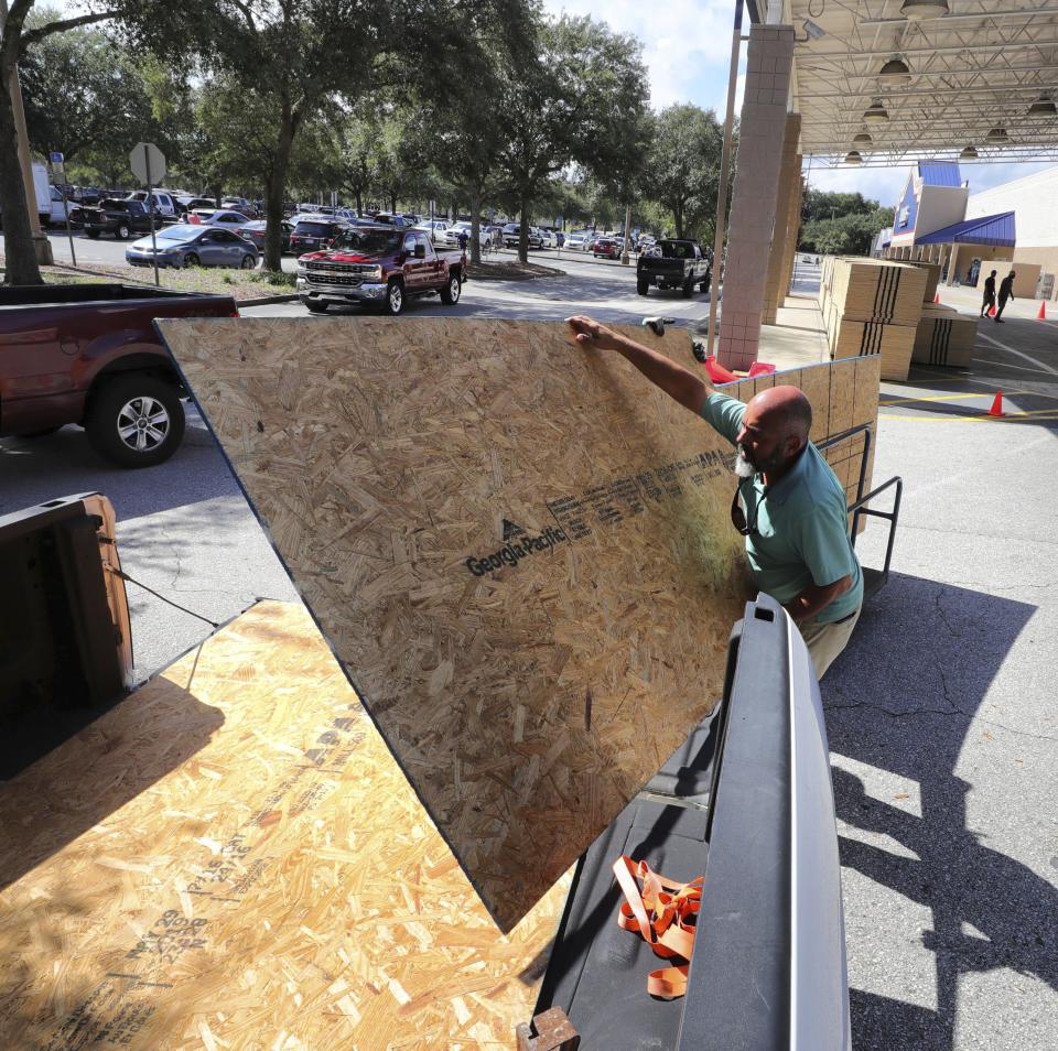 A customer loads plywood in his truck at a Lowes store in Altamonte Springs, Fla., Friday, Aug. 30, 2019, as central Florida residents prepare for a possible strike by Hurricane Dorian. (Joe Burbank/Orlando Sentinel via AP)