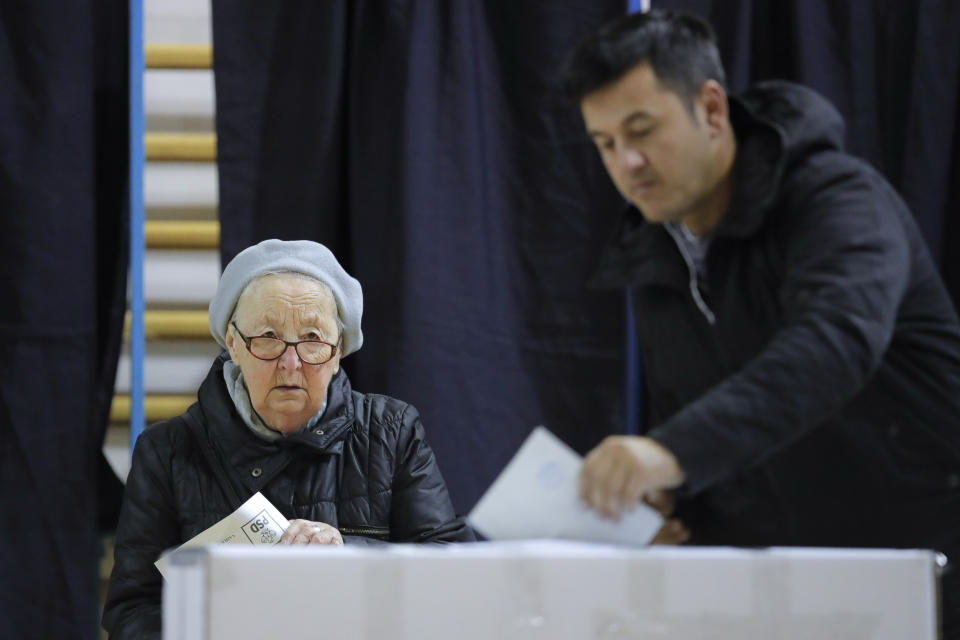 People vote in Bucharest, Romania, Sunday, Nov. 24, 2019. Romanians are voting in a presidential runoff election in which incumbent Klaus Iohannis is vying for a second term, facing Social Democratic Party leader Viorica Dancila, a former prime minister, in Sunday's vote. (AP Photo/Vadim Ghirda)