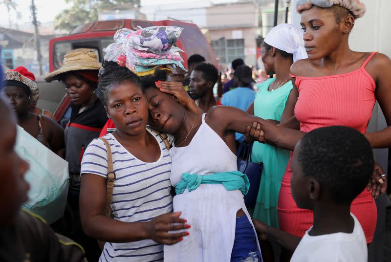 People react at a crime scene, in Port-au-Prince