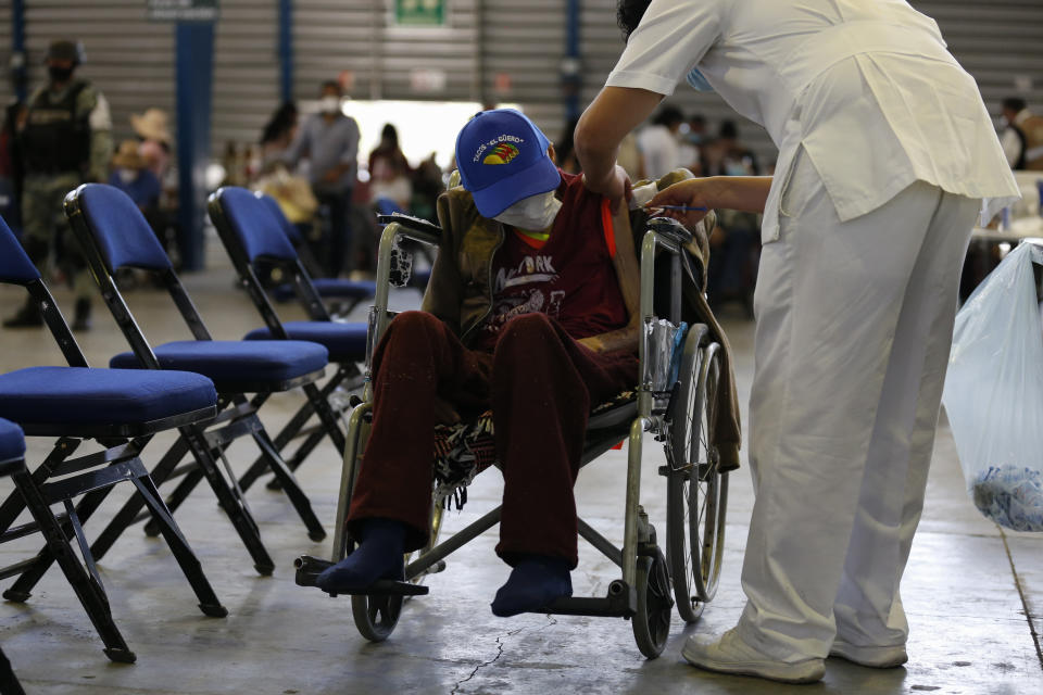 A medical worker injects a man with a dose of the Russian COVID-19 vaccine Sputnik V at the Palacio de los Deportes, in the Iztacalco borough of Mexico City, Wednesday, Feb. 24, 2021. (AP Photo/Rebecca Blackwell)