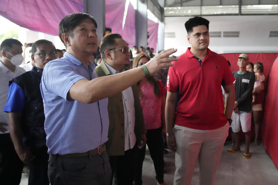 Philippine President Ferdinand Marcos Jr., front left, visits an evacuation center in Guinobatan town, Albay province, northeastern Philippines, Wednesday, June 14, 2023. A gentle eruption of the Philippines' most active volcano that has forced nearly 18,000 people to flee to emergency shelters could last for months and create a protracted crisis, officials said Wednesday. (AP Photo/Aaron Favila)