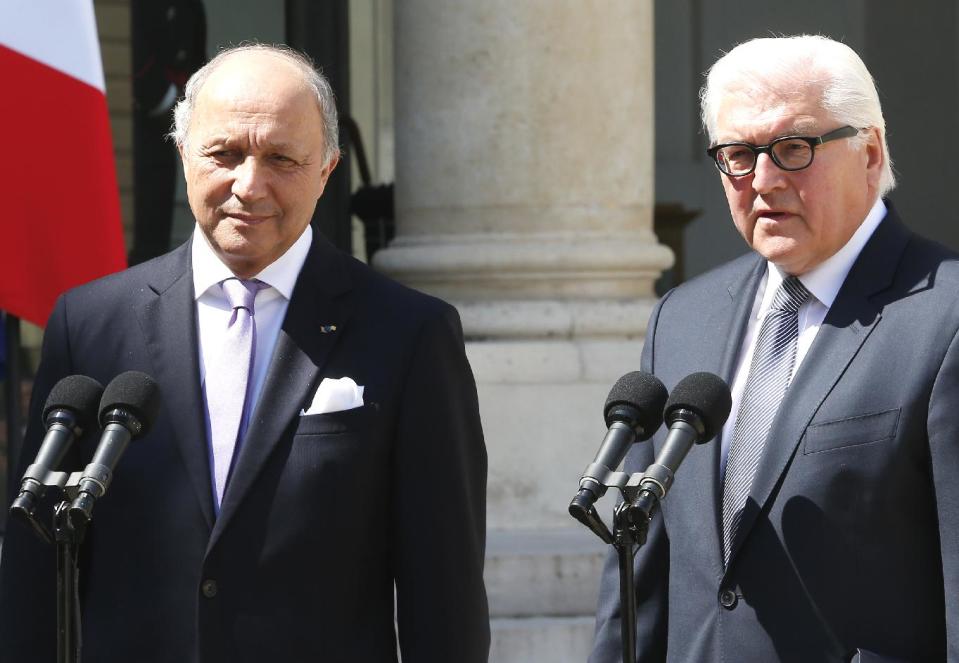 French Foreign Minister Laurent Fabius, left, and German counterpart Frank-Walter Steinmeier, right, talks to reporters after a weekly Cabinet meeting in the Elysee Palace in Paris, Wednesday, May 14, 2014.(AP Photo/Jacques Brinon)