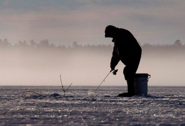 Someone ice fishing on Pigeon Lake in the Kawarthas region in February 2017. People can still fish for what's in season, but they can't do it out of a hut after certain dates this month. (Fred Thornhill/Canadian Press - image credit)