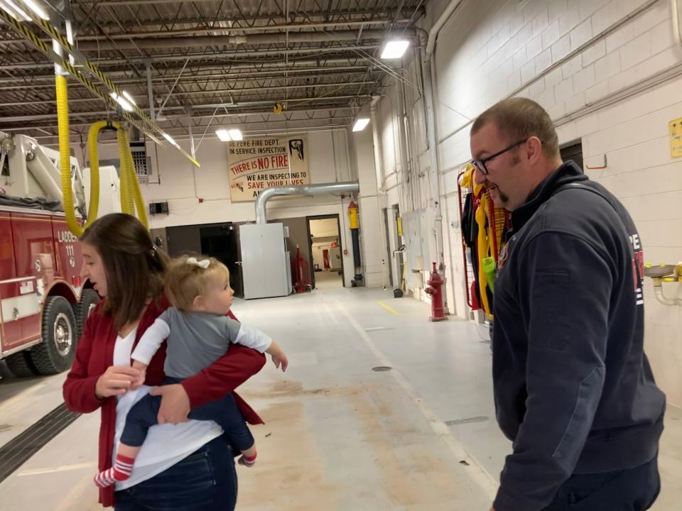 Tony Rottier, a paramedic with De Pere Fire Rescue, shares a moment with Ainsley Gossen, 9 months old, while her mother Tammy Gossen talks to her 4-year-old son Owen Gossen inside De Pere Fire Station on Friday. Rottier was part of the paramedics team who showed up at the Gossen's the night Ainsley was born, and cut Ainsley's umbilical cord.