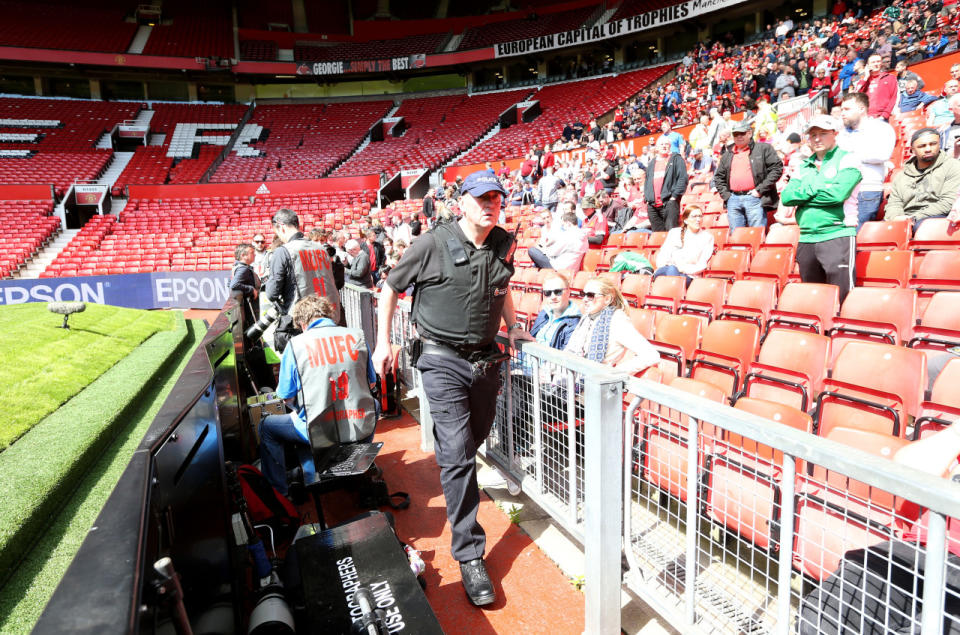 A police officer during the English Premier League match at Old Trafford in Manchester, England. The stadium was evacuated and the match between Manchester United and AFC Bournemouth was abandoned after a suspicious package was discovered prior to kickoff on May 15, 2016. (Martin Rickett/PA via AP)