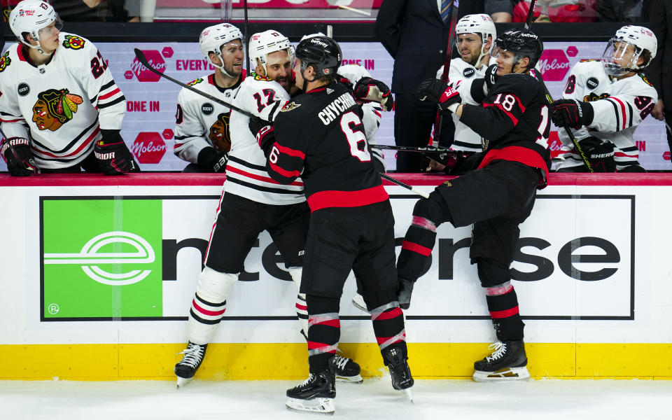 Ottawa Senators defenseman Jakob Chychrun (6) pushes with Chicago Blackhawks left wing Nick Foligno (17) as Ottawa Senators centre Tim Stutzle (18) looks on during the second period of an NHL hockey game in Ottawa, Ontario, on Thursday, March 28, 2024. (Sean Kilpatrick/The Canadian Press via AP)