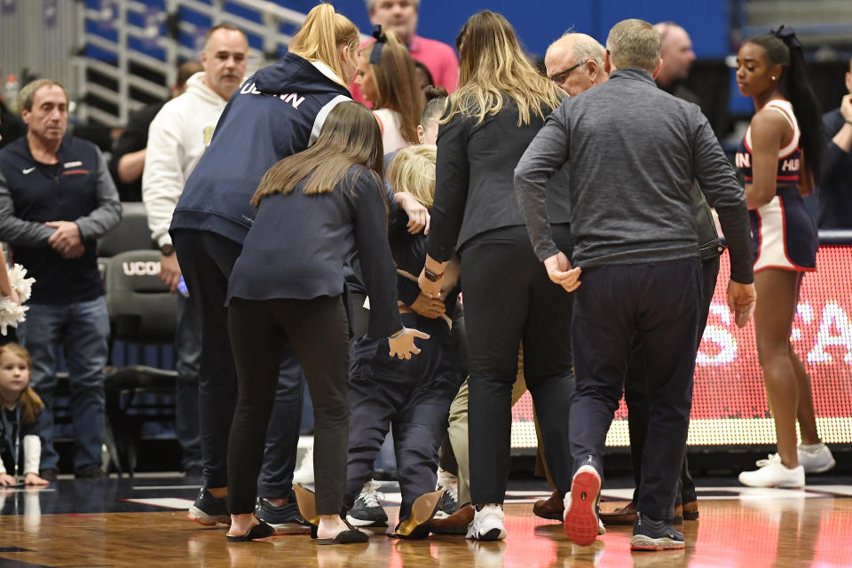Connecticut players and staff surround Associate Head Coach Chris Dailey after a medical emergency before an NCAA basketball game against North Carolina State, Sunday, Nov. 20, 2022, in Hartford, Conn. (AP Photo/Jessica Hill)