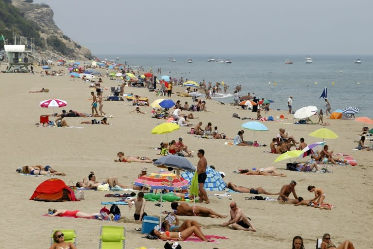 People sunbathe and swim on August 17, 2016 at a beach in Leucate, where the burkini is probihibited by an order of the mayor