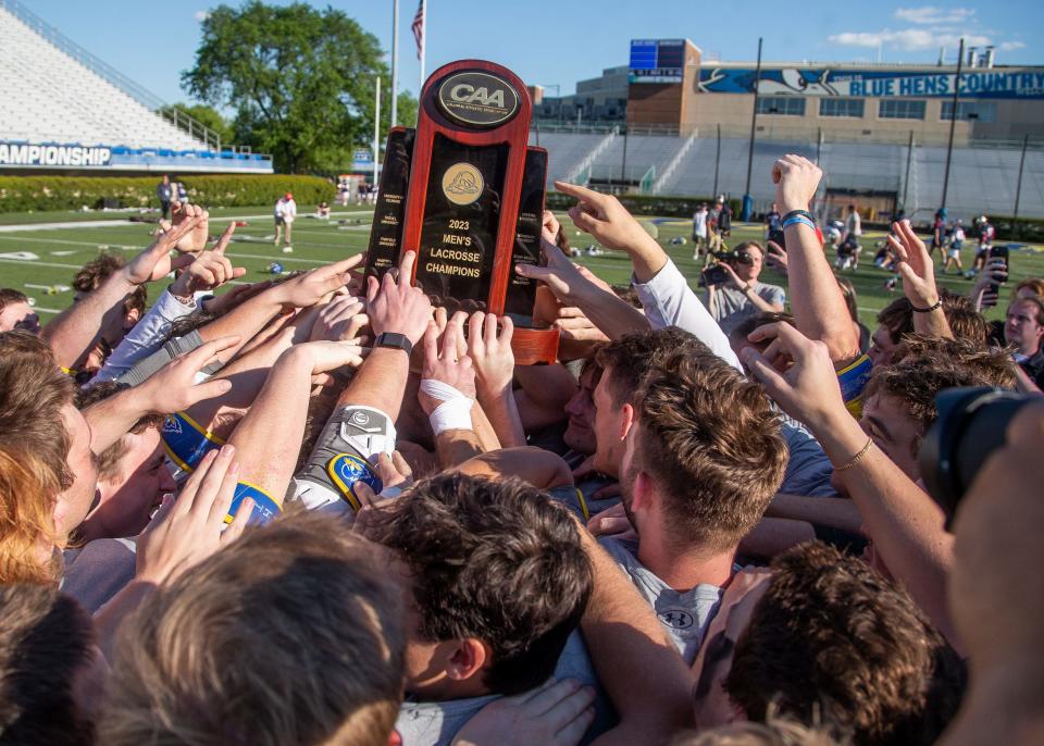 Delaware players hoist the CAA lacrosse championship trophy Saturday at Delaware Stadium.
