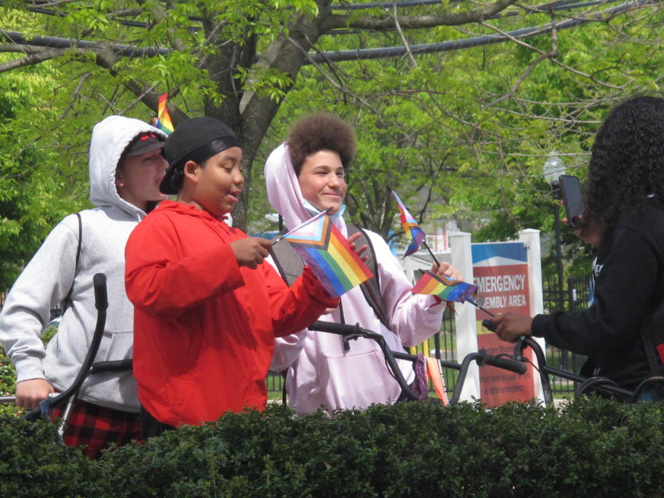 Students hold rainbow flags during a protest in Neptune N.J., on Friday, May 7, 2021, against a school vice principal who was filmed tossing beer at people who were videotaping his wife's rant against a transgender woman's use of a public restroom at an outdoor restaurant in Galloway Township N.J. in April. (AP Photo/Wayne Parry)