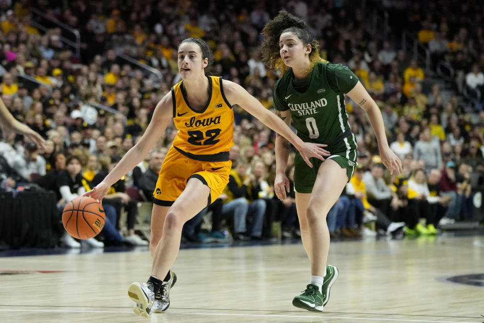 Iowa guard Caitlin Clark (22) drives past Cleveland State guard Mickayla Perdue (0) during the first half of an NCAA college basketball game, Saturday, Dec. 16, 2023, in Des Moines, Iowa. (AP Photo/Charlie Neibergall)