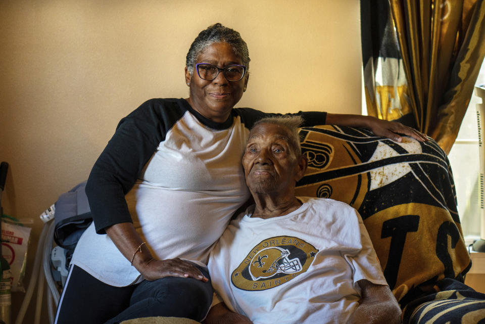 FILE - Vanessa Brooks poses for a portrait with her father Lawrence Brooks in his room at their home in New Orleans, on Sept. 8, 2021. For Veterans Day, a group of Democratic lawmakers is reviving an effort to pay the families of Black servicemen who fought on behalf of the nation during World War II for benefits they were denied or prevented from taking full advantage of when they returned home from war. (AP Photo/Kathleen Flynn, File)