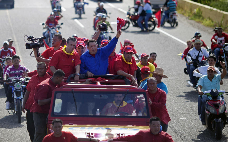 Venezuela's President Hugo Chavez waves to supporters from the top of a vehicle driven by Venezuela's Foreign Minister Nicolas Maduro during a campaign caravan from Barinas to Caracas, in Sabaneta, Venezuela, Monday, Oct. 1, 2012. Venezuela's presidential election is scheduled for Oct. 7. (AP Photo/Rodrigo Abd)