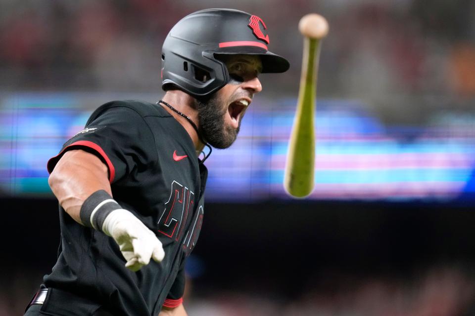 Nick Martini flips his bat in celebration after hitting  a game-tying home run in the bottom of the ninth inning in the second game of Friday's doubleheader with the Cubs. The Reds walked it off on a two-out RBI single in the unlikely 3-2 victory.