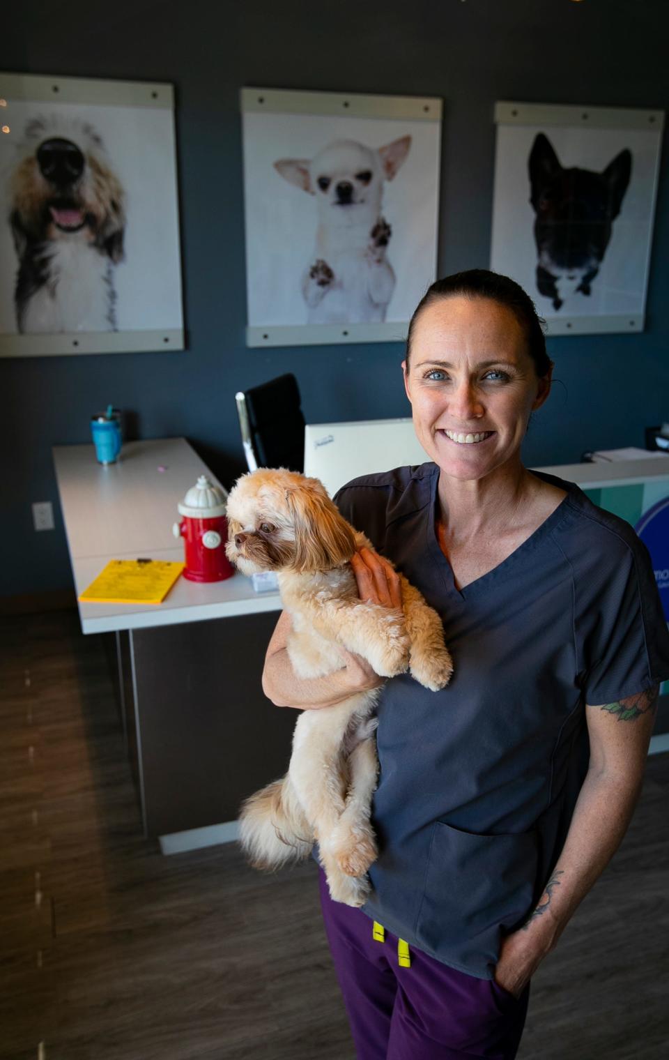 Miche Dietz, one of the co-owners of Glamour Paws in Cape Coral, poses for a portrait with her dog earlier this month.