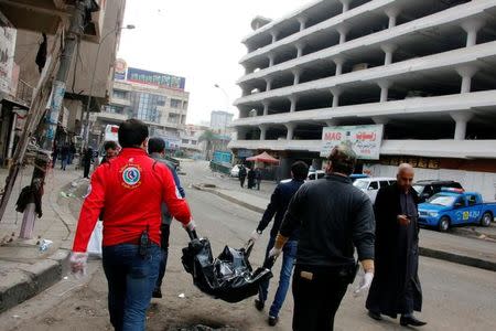 ATTENTION EDITORS - VISUALS COVERAGE OF SCENES OF INJURY OR DEATHMedical personnel carry the body of a victim at the site of a bomb attack at a market in central Baghdad, Iraq, December 31, 2016. REUTERS/Ali al-Mashhadani