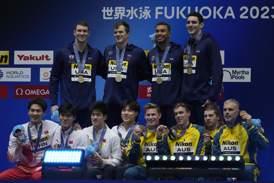 Gold medalist Team U.S., top, silver medalist Team China, seated left, and bronze medalist Team Australia celebrate on the podium during the medal ceremony for the men's 4x100m medley relay at the World Swimming Championships in Fukuoka, Japan, Sunday, July 30, 2023. (AP Photo/Lee Jin-man)