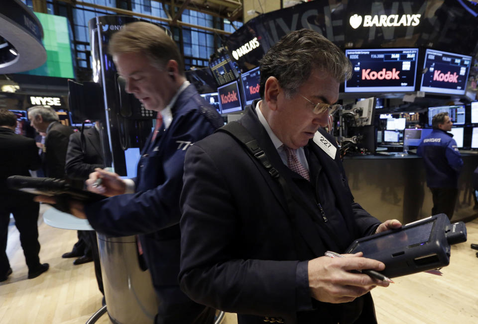 Traders F. Hill Creekmore, left, and John Bishop work on the floor of the New York Stock Exchange Wednesday, Jan. 8, 2014. Stocks are mostly lower in early trading as investors hold back ahead of the release of the latest news from the Federal Reserve. (AP Photo/Richard Drew)