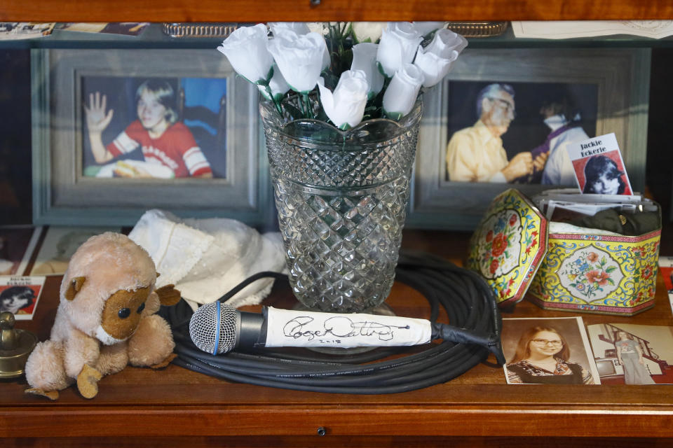 In this Thursday, Nov. 21, 2019 photo, a signed microphone by The Who's Roger Daltrey is displayed in a memorial cabinet at the Finneytown High School secondary campus in Finneytown, Ohio, along with other mementoes of the three Finneytown students killed in a stampede at the band's 1979 Cincinnati concert. Tragedy four decades ago linked the British rock band to the small suburban city in Ohio. In recent years, members of the community and the band have bonded through a project to memorialize the teens. (AP Photo/John Minchillo)