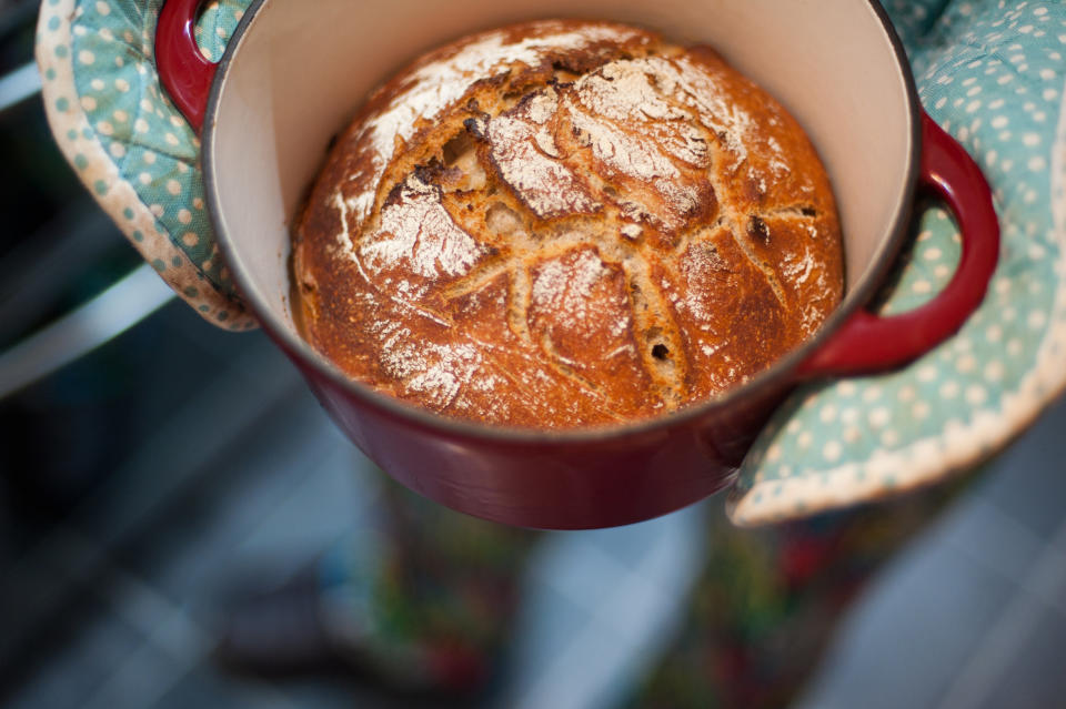 Home baked bread fresh out of the oven - in a dutch oven being held in oven gloves (Getty Images stock)