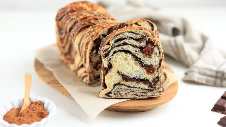 Chocolate brioche sits on wooden board 