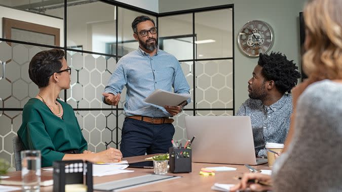 Confident mature businessman giving a presentation to his team in office.