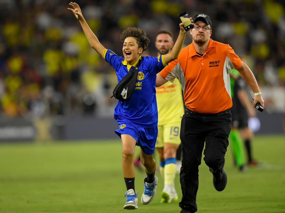 Aug 8, 2023; Nashville, TN, USA;  Club America runs off the field with security after running onto the field against the Nashville SC during the second half at GEODIS Park.